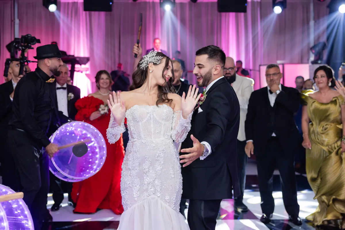 Bride and groom dancing surrounded by guests and live drumline at The Palace Center